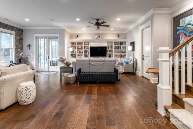 a living room with furniture a flat screen tv and a window
