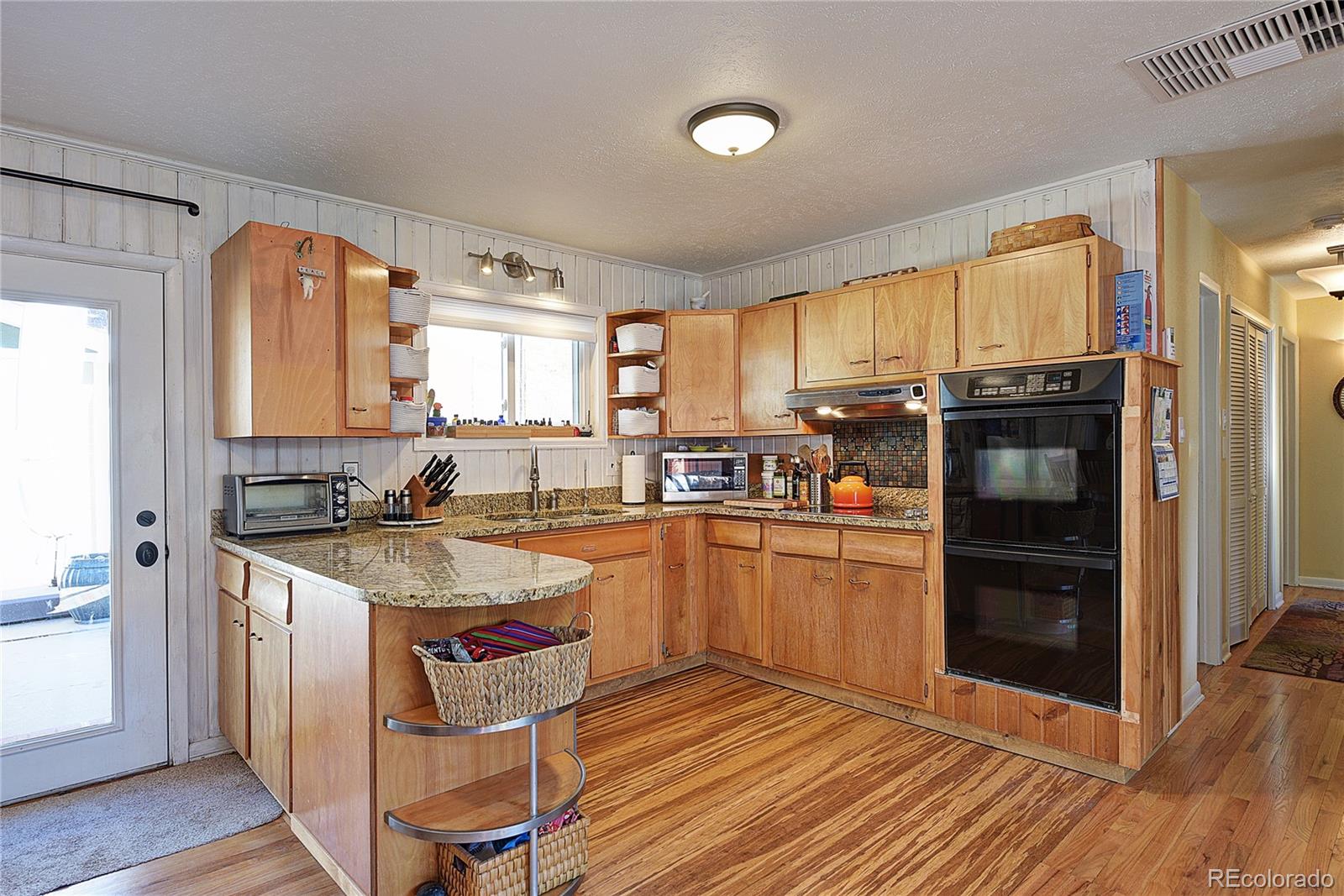 5384 Olde Stage Road Boulder, CO 80302 - Photo 5 of 28 a kitchen with stainless steel appliances granite countertop a refrigerator a sink dishwasher a stove and white countertops with wooden floor