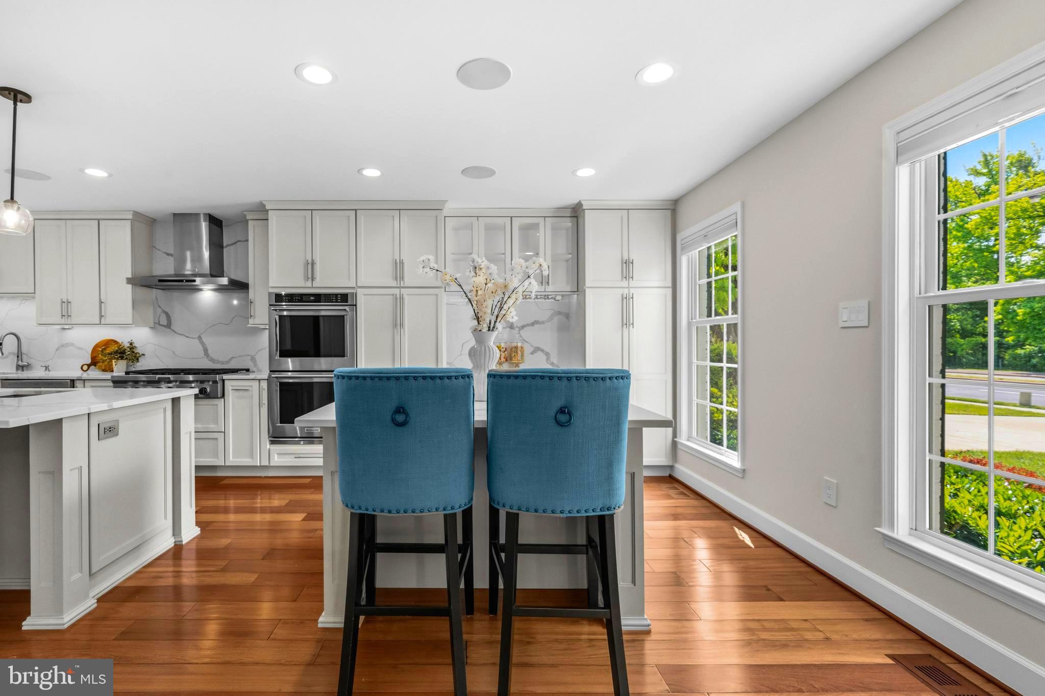 4007 West Braddock Road Alexandria, VA 22304 - Photo 9 of 52 a kitchen with stainless steel appliances granite countertop a stove a refrigerator a microwave oven a dining table and chairs with wooden floor