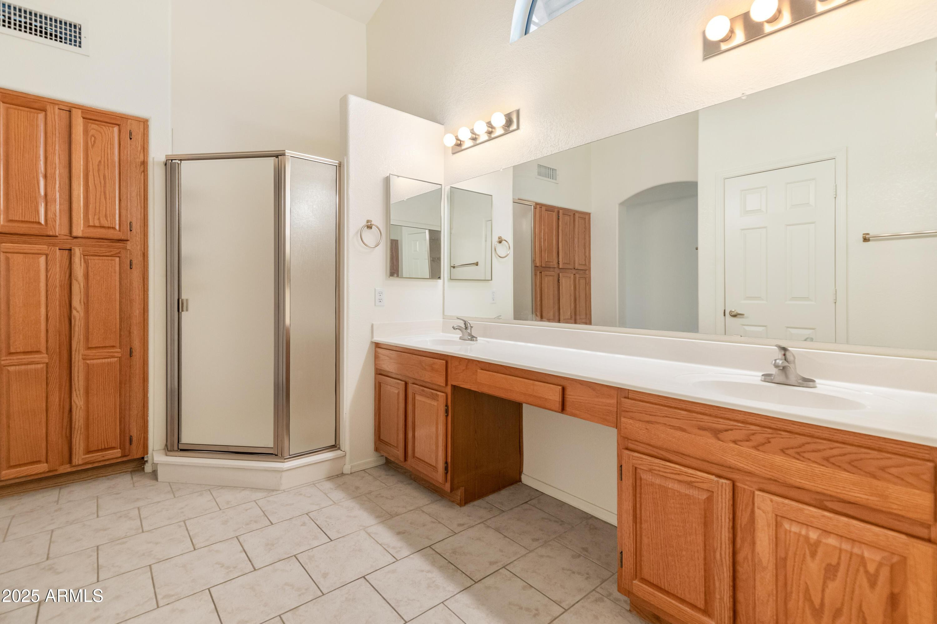 14543 West Bison Path Surprise, AZ 85374 - Photo 19 of 42 a spacious bathroom with a double vanity sink a mirror and a bathtub