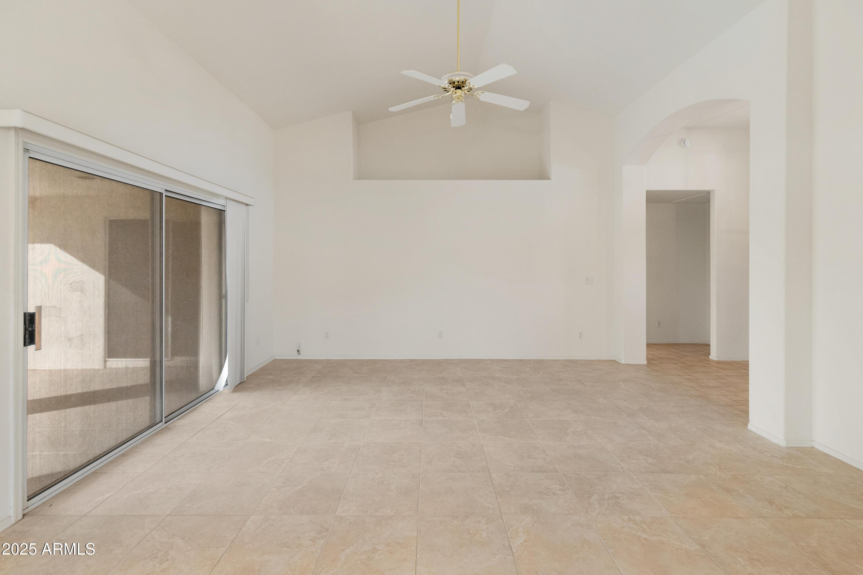 14543 West Bison Path Surprise, AZ 85374 - Photo 29 of 42 an empty room with a ceiling fan and glass door