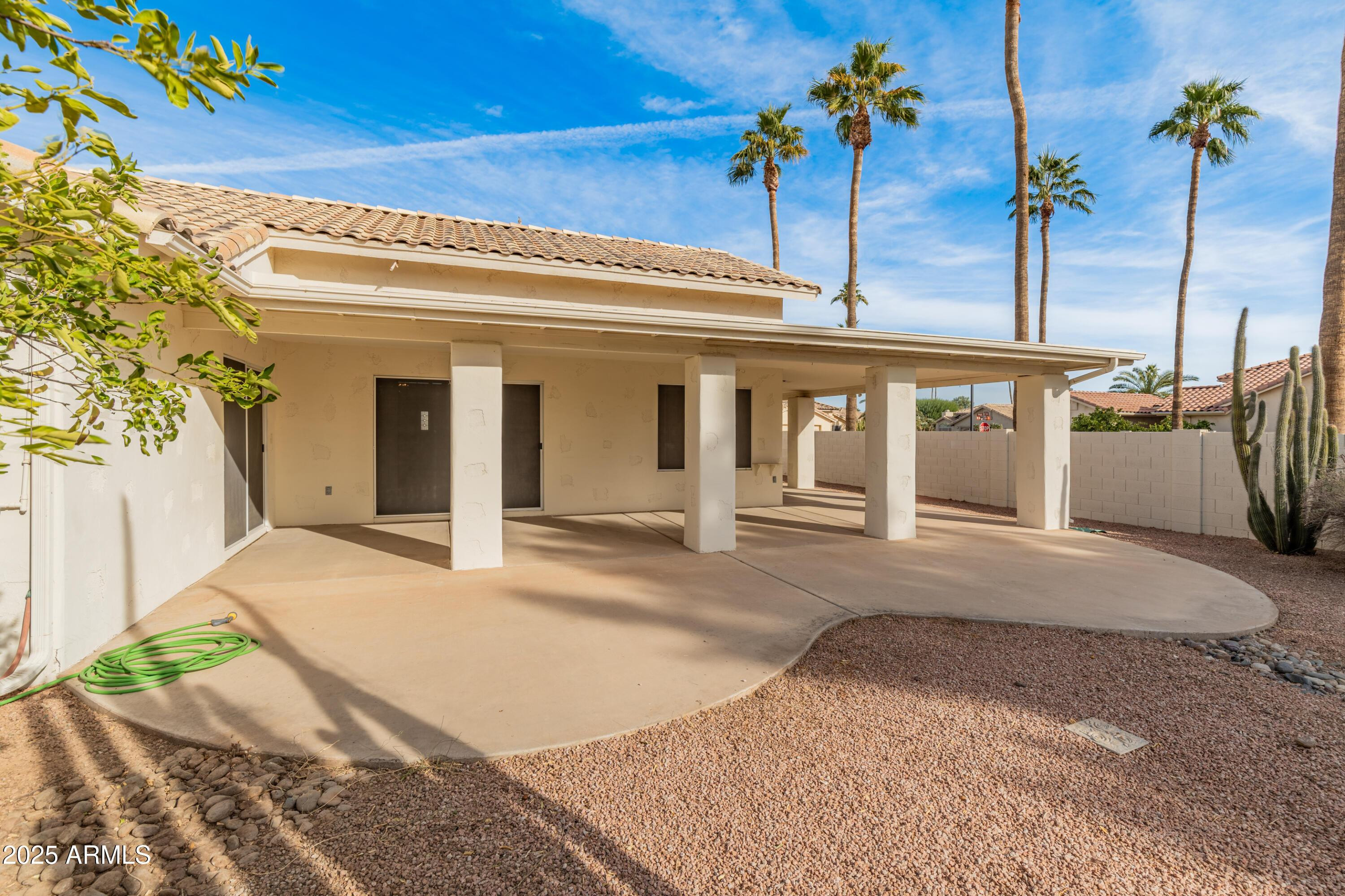 14543 West Bison Path Surprise, AZ 85374 - Photo 36 of 42 a view of a house with a floor to ceiling window and potted plants