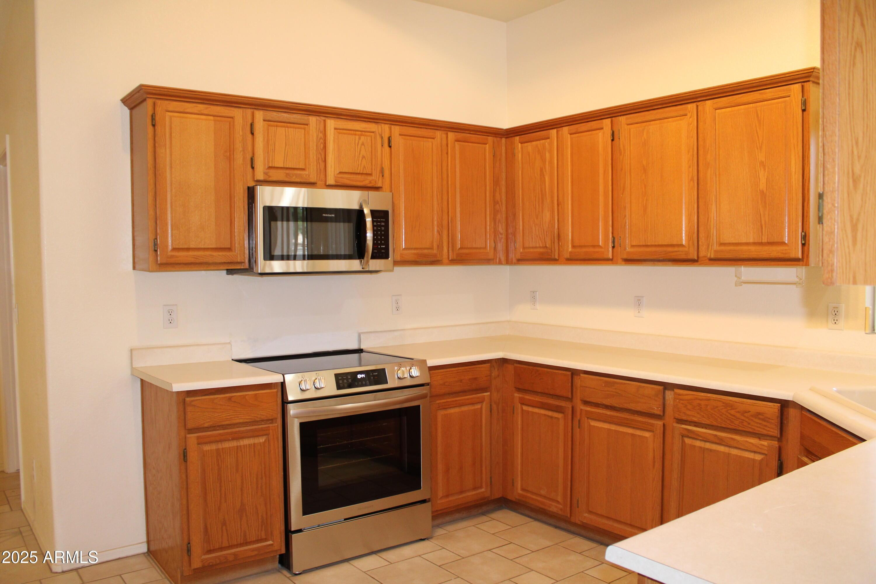14543 West Bison Path Surprise, AZ 85374 - Photo 5 of 42 a kitchen with sink cabinets and microwave oven