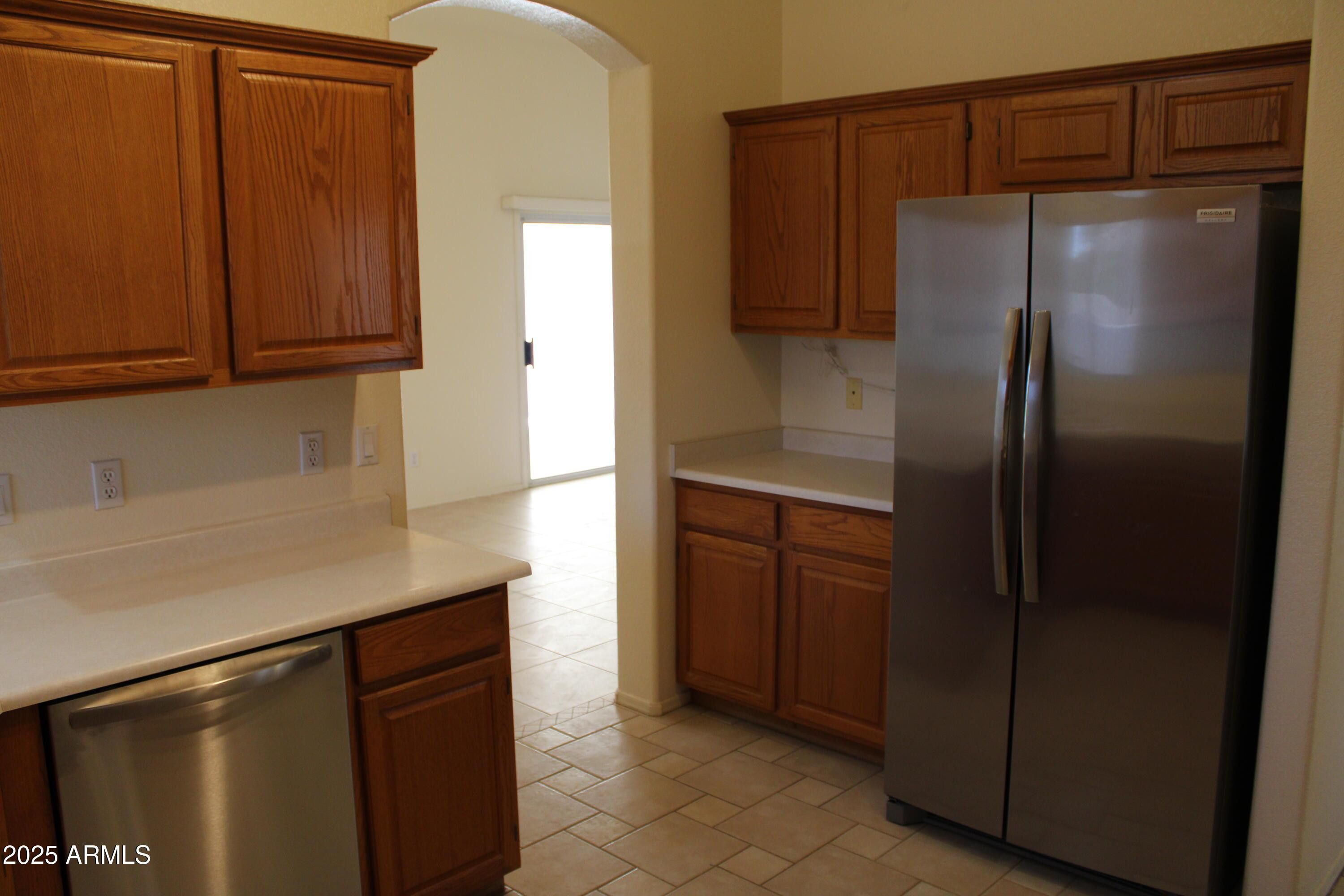 14543 West Bison Path Surprise, AZ 85374 - Photo 7 of 42 a kitchen with metallic refrigerator freezer and a dishwasher