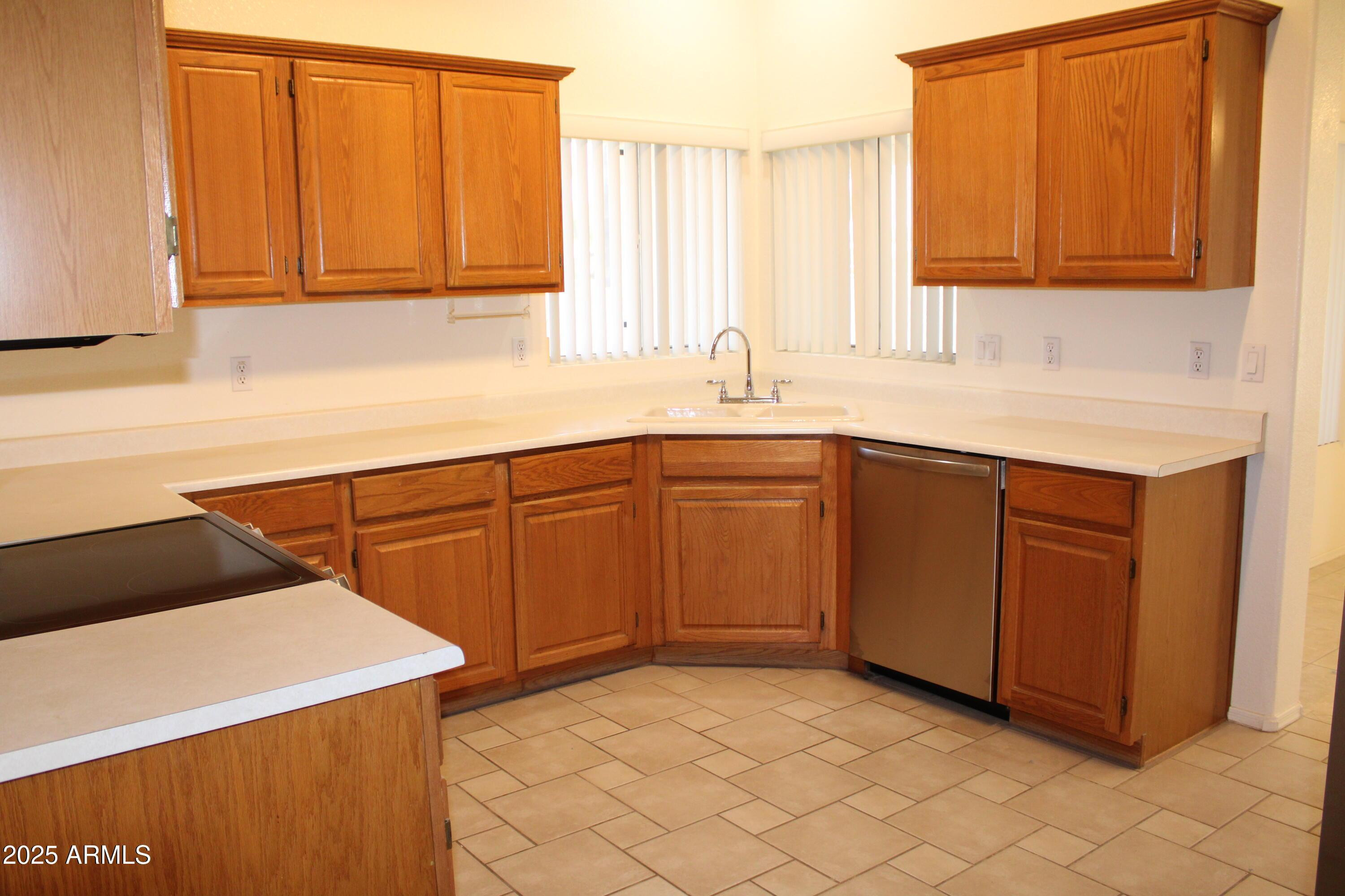 14543 West Bison Path Surprise, AZ 85374 - Photo 8 of 42 a kitchen with a sink cabinets and a microwave