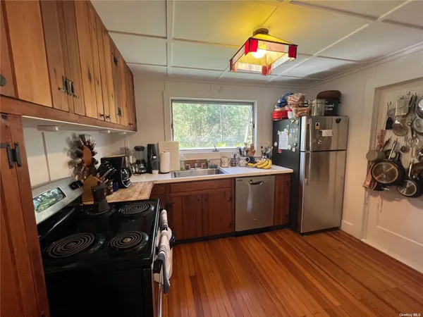 a kitchen with a refrigerator wooden floor and window
