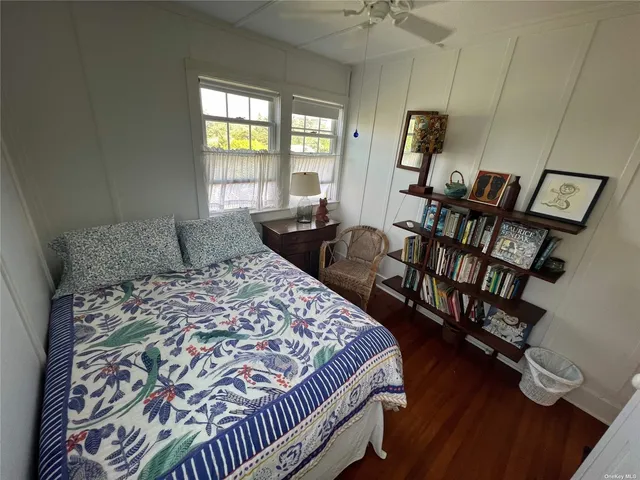 a bedroom with a bed a flat screen tv and a large window