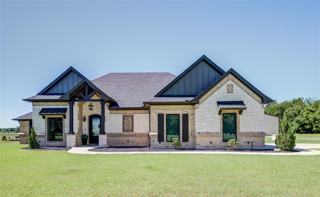 139 County Road 2525 Decatur, TX 76234 - Photo 1 of 1 View of front of house with board and batten siding, a front yard, a shingled roof, and stone siding