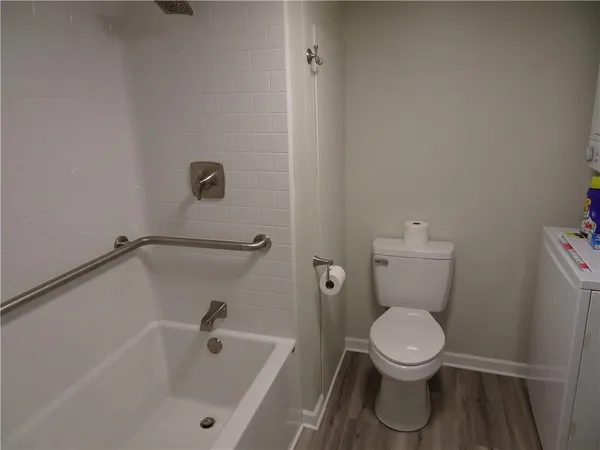 a white toilet sitting next to a bath tub
