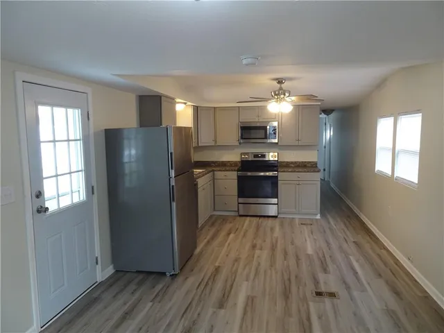 a kitchen with wooden floors and stainless steel appliances
