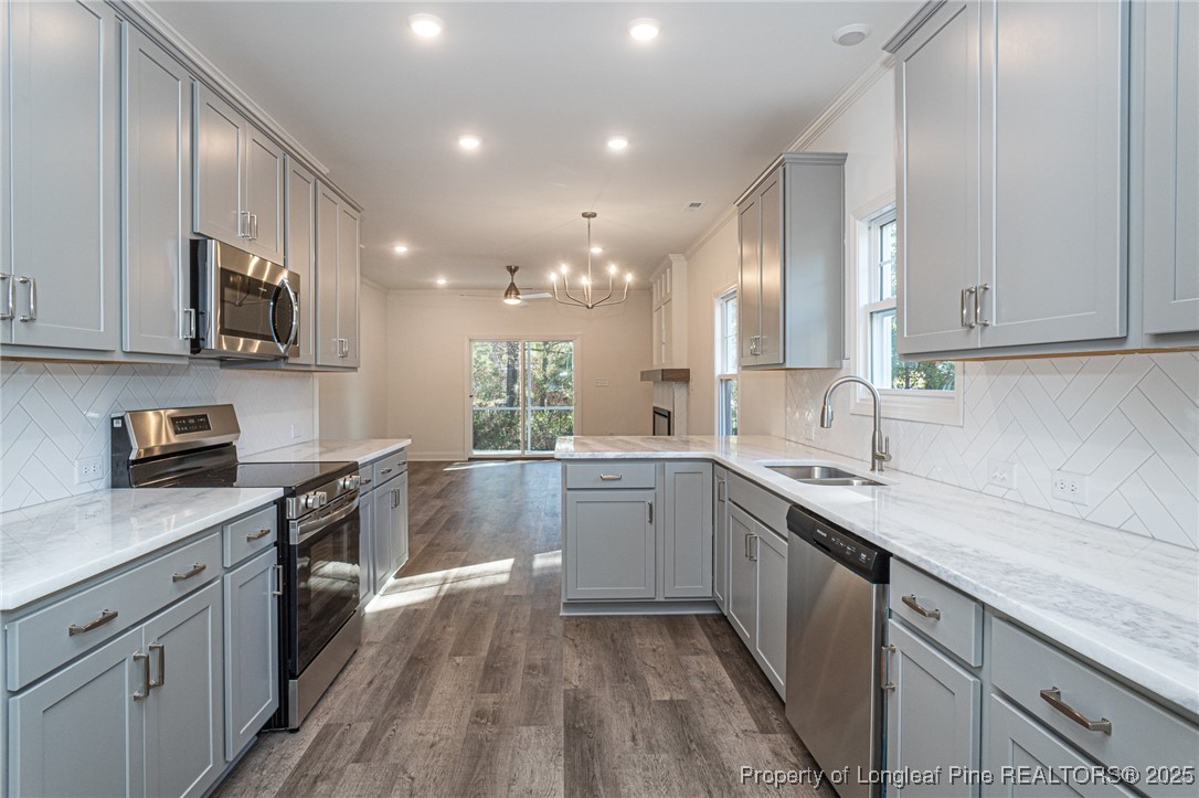 3211 Nottinghill Road Fayetteville, NC 28311 - Photo 8 of 39 a kitchen with a sink dishwasher a stove top oven a refrigerator with wooden cabinets and floor
