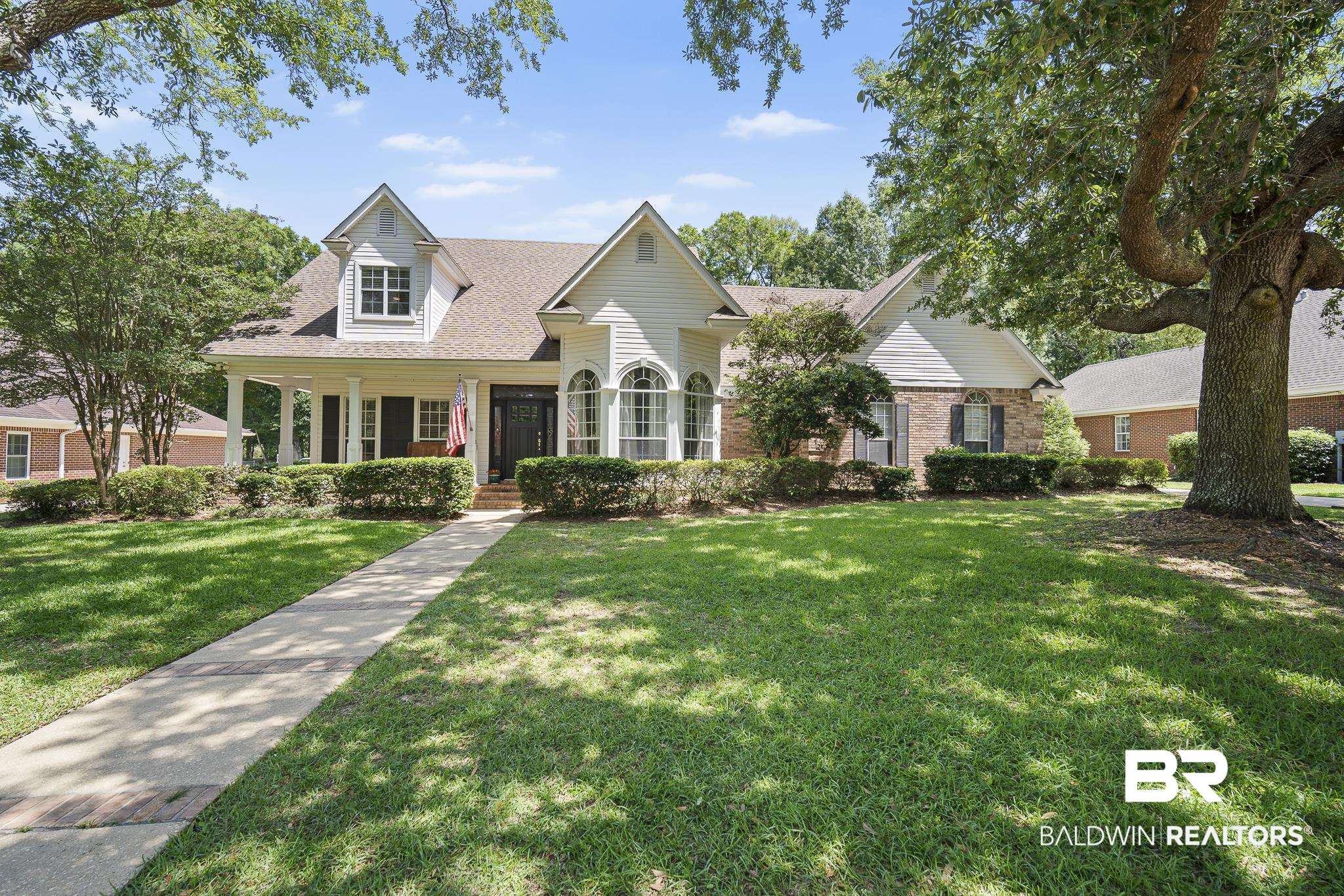 402 Potters Mills Road Daphne, AL 36526 - Photo 1 of 45 View of front of property featuring a front yard, a porch, brick siding, and a shingled roof