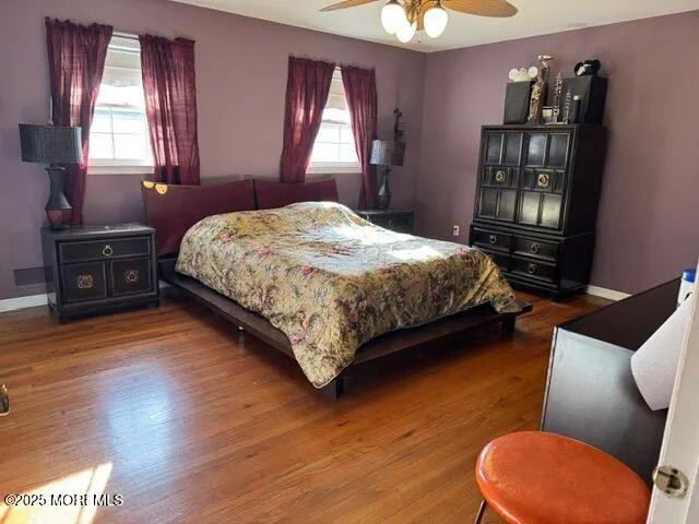 a bedroom with a bed wooden floor and window