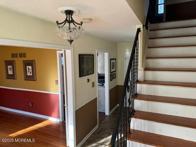 a view of a hallway with wooden floor and staircase