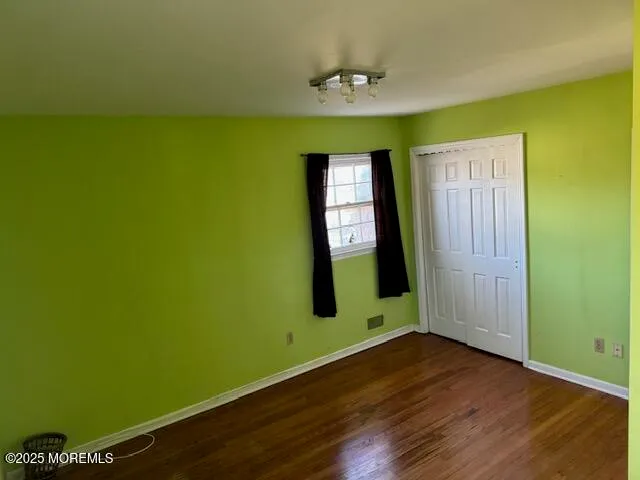 a view of room with window and wooden floor