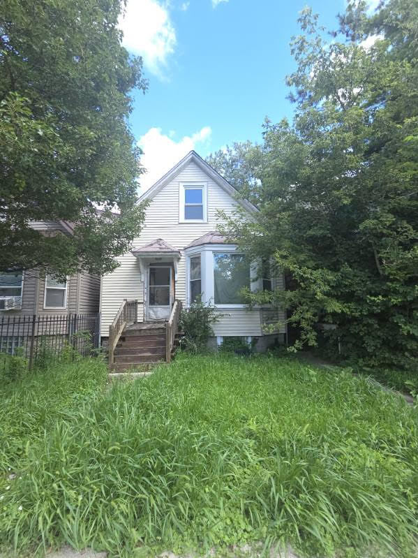 a front view of a house with a garden and trees