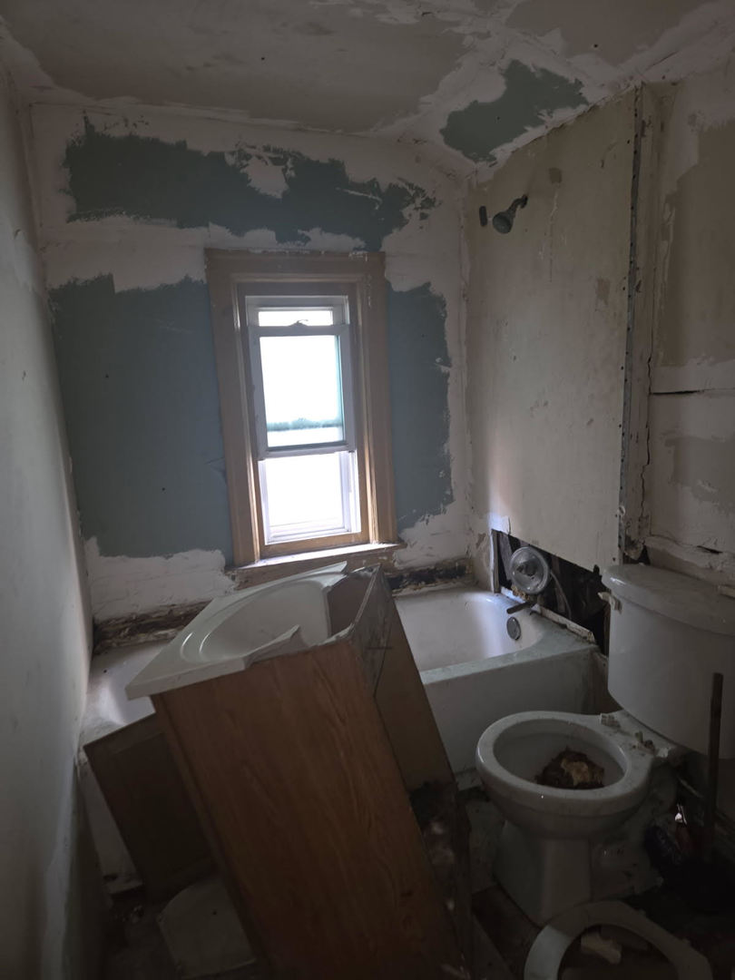 6619 South Aberdeen Street Chicago, IL 60621 - Photo 16 of 17 a bathroom with a granite countertop sink a toilet and tub