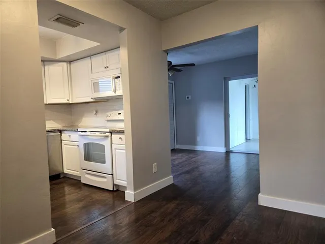 a view of kitchen with wooden floor and electronic appliances