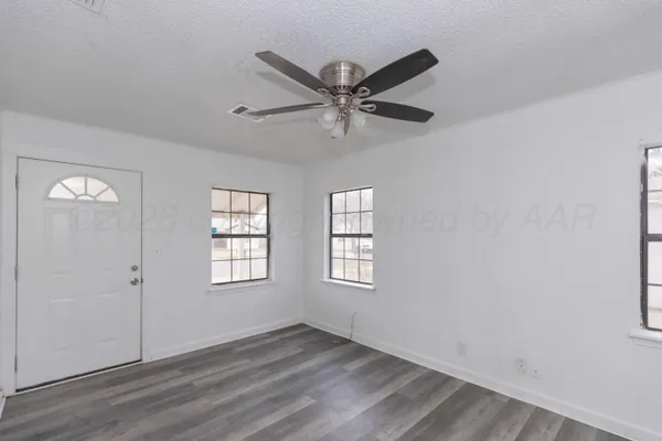 a view of a livingroom with wooden floor and a ceiling fan
