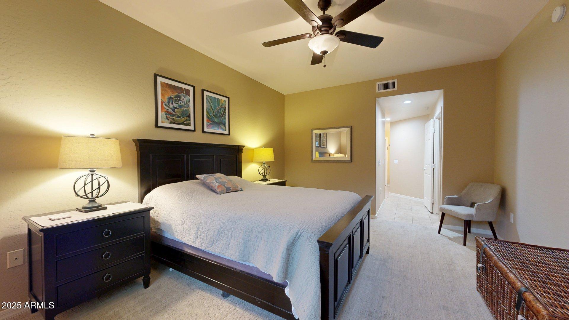 20121 North 76th Street, Unit 1047 Scottsdale, AZ 85255 - Photo 15 of 22 a bedroom with a bed and a chandelier