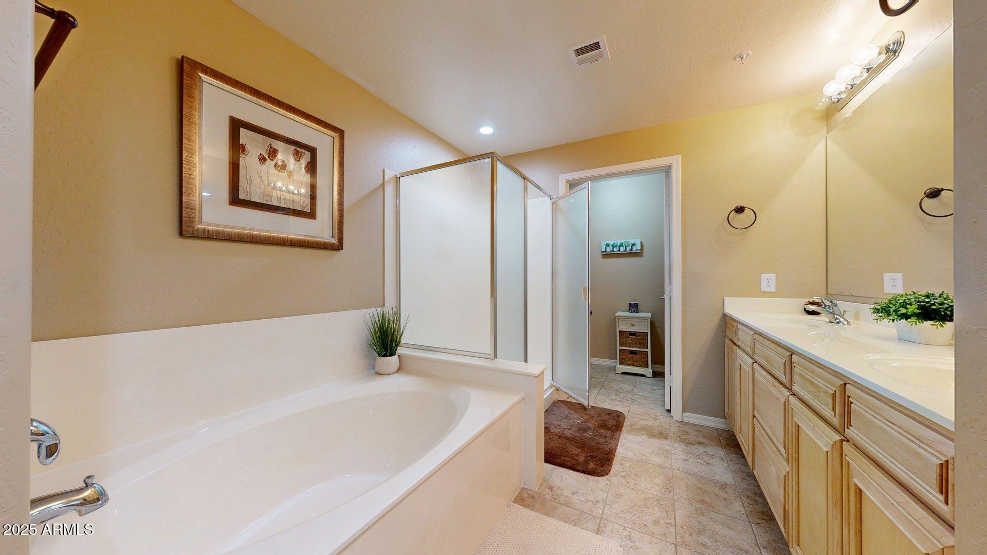 20121 North 76th Street, Unit 1047 Scottsdale, AZ 85255 - Photo 16 of 22 a spacious bathroom with a tub double vanity and mirrors