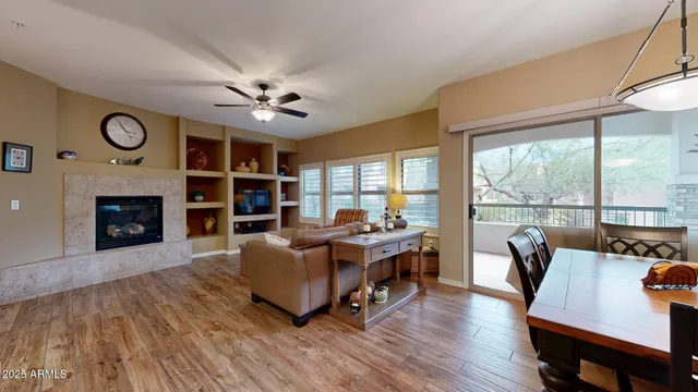 a living room with furniture a fireplace and a large window