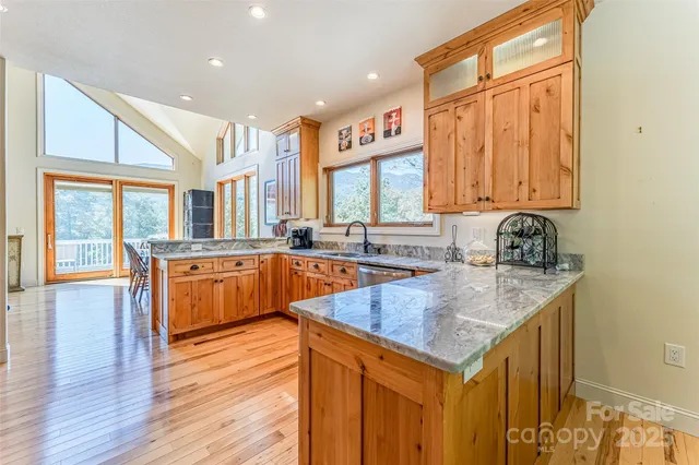 a kitchen with a sink a counter top space and living room area