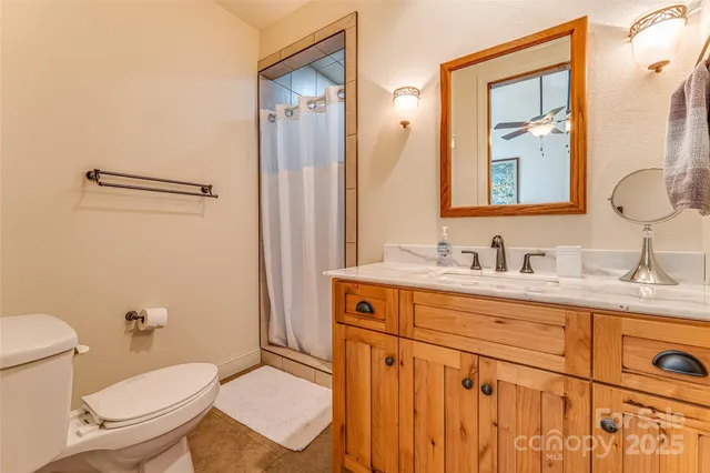 a bathroom with a granite countertop toilet sink and mirror