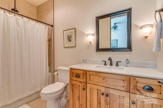 a bathroom with a granite countertop sink mirror vanity and toilet