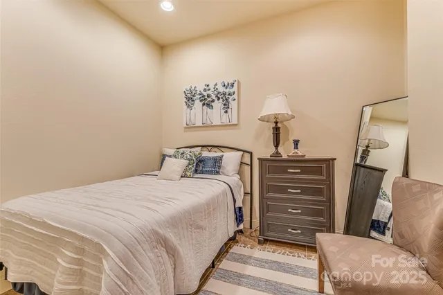 a bedroom with a bed and a lamp with the dresser