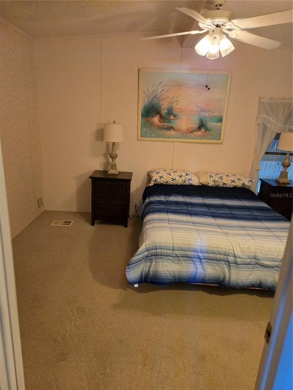 6162 Redwing Avenue Englewood, FL 34224 - Photo 11 of 23 a bedroom with a bed and a chandelier