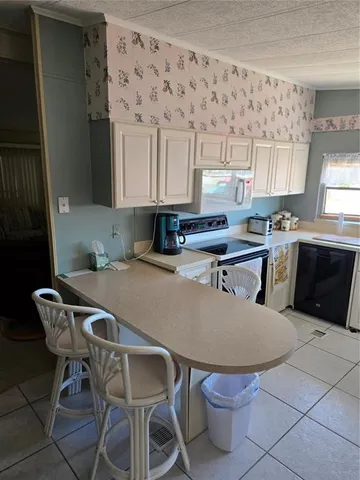 a kitchen with a table chairs sink and cabinets