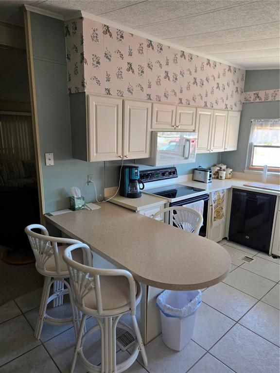 6162 Redwing Avenue Englewood, FL 34224 - Photo 2 of 23 a kitchen with a table chairs sink and cabinets