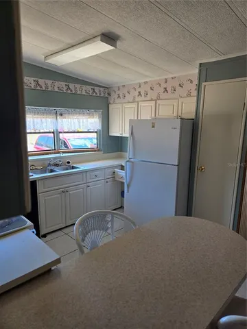 a kitchen with refrigerator and window