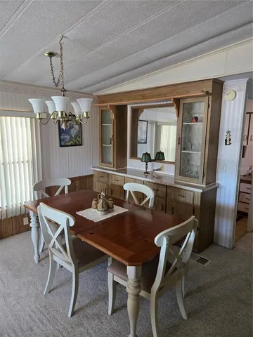 a dining room with furniture a chandelier and window