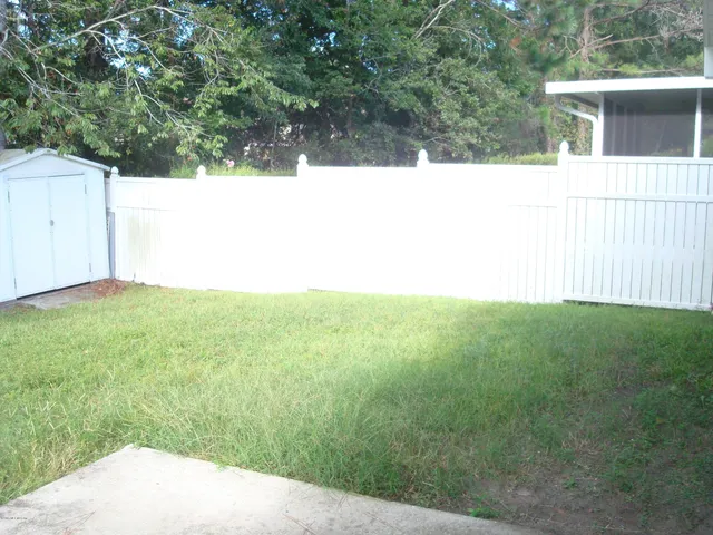 a view of a backyard with wooden fence