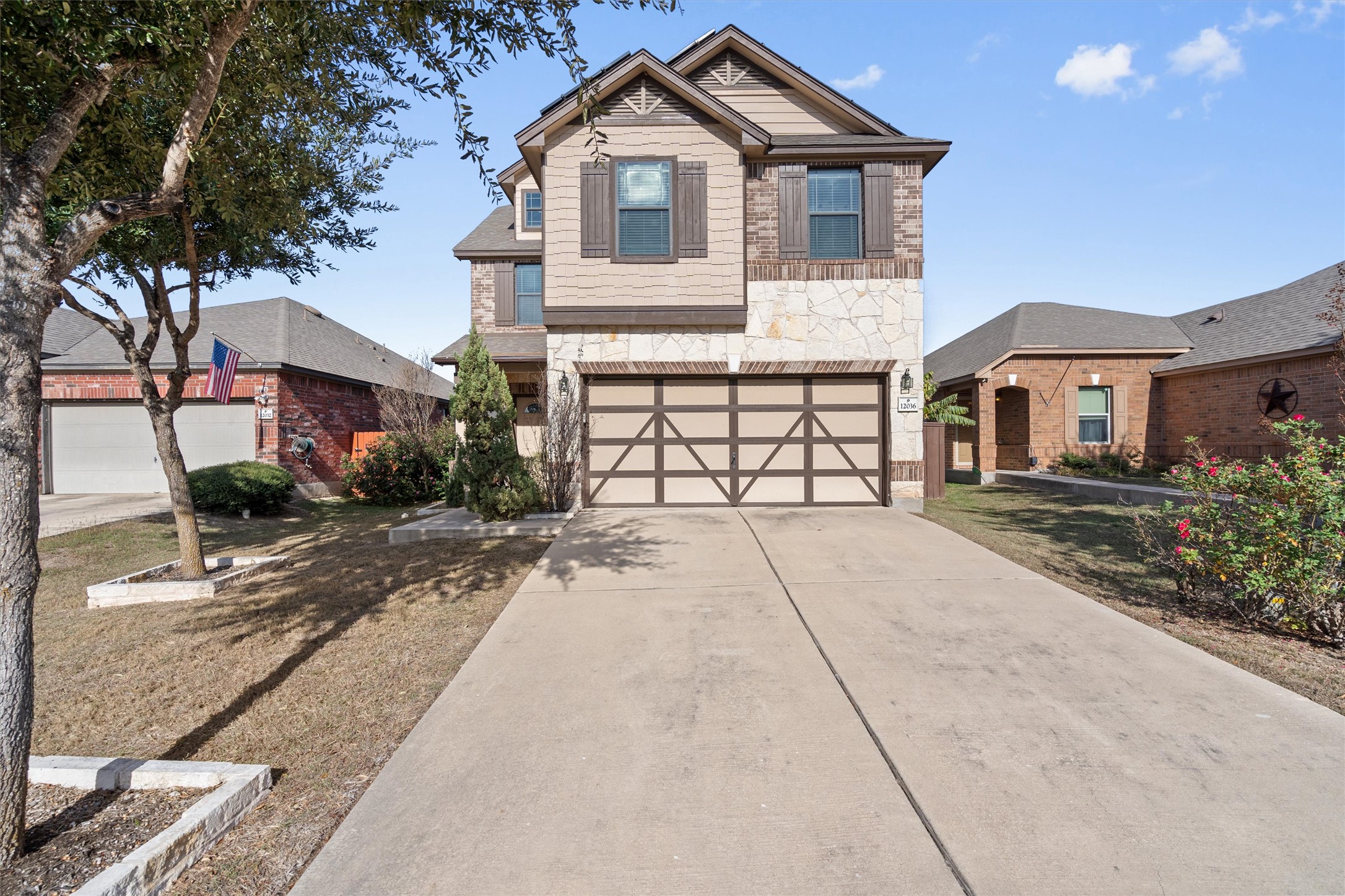 View of front of property with stone siding, concrete driveway, and a garage