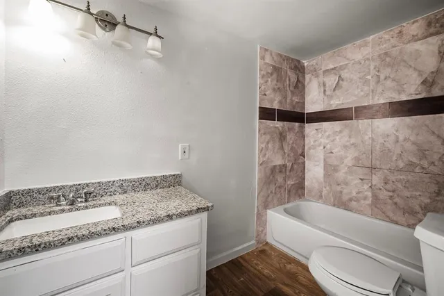 a bathroom with a granite countertop sink toilet and shower