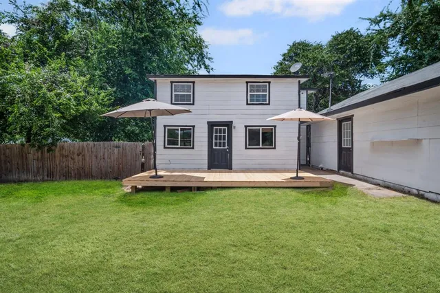 a view of a house with a yard and deck