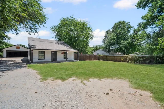 a front view of a house with a garden and trees