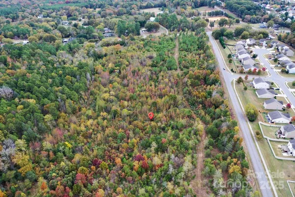 an aerial view of residential houses with outdoor space and trees