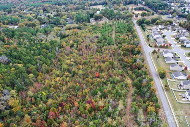 an aerial view of residential houses with outdoor space and trees