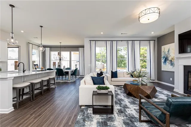 a living room with fireplace furniture and a large window