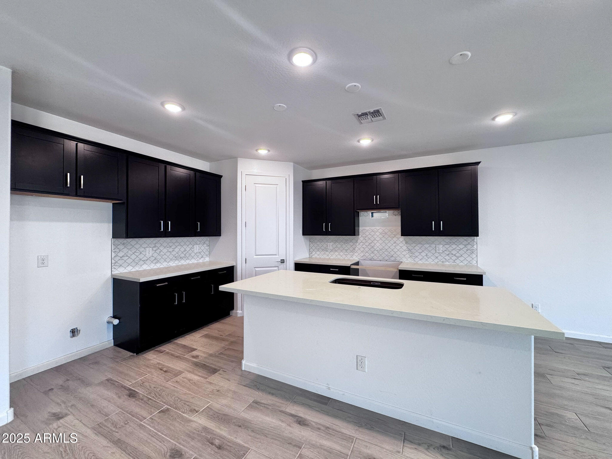 15740 West Camden Avenue Waddell, AZ 85355 - Photo 12 of 38 a large kitchen with stainless steel appliances kitchen island granite countertop a stove a sink and a microwave