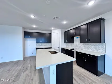 a kitchen with stainless steel appliances kitchen island a cabinets and wooden floor