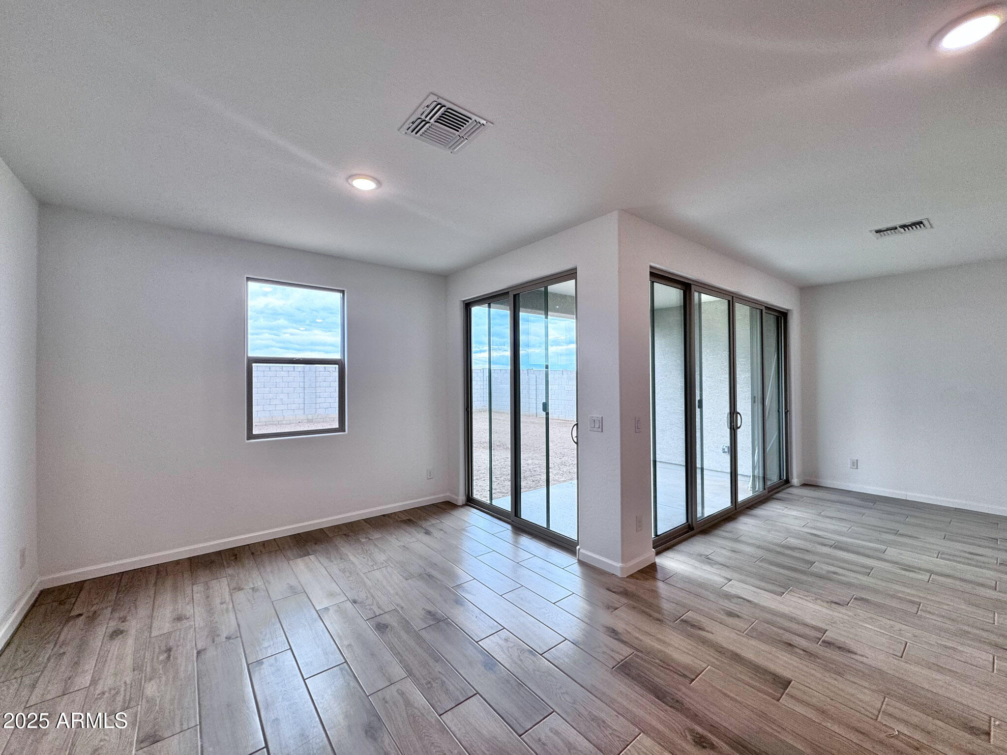 15740 West Camden Avenue Waddell, AZ 85355 - Photo 14 of 38 a view of an empty room with wooden floor and a window
