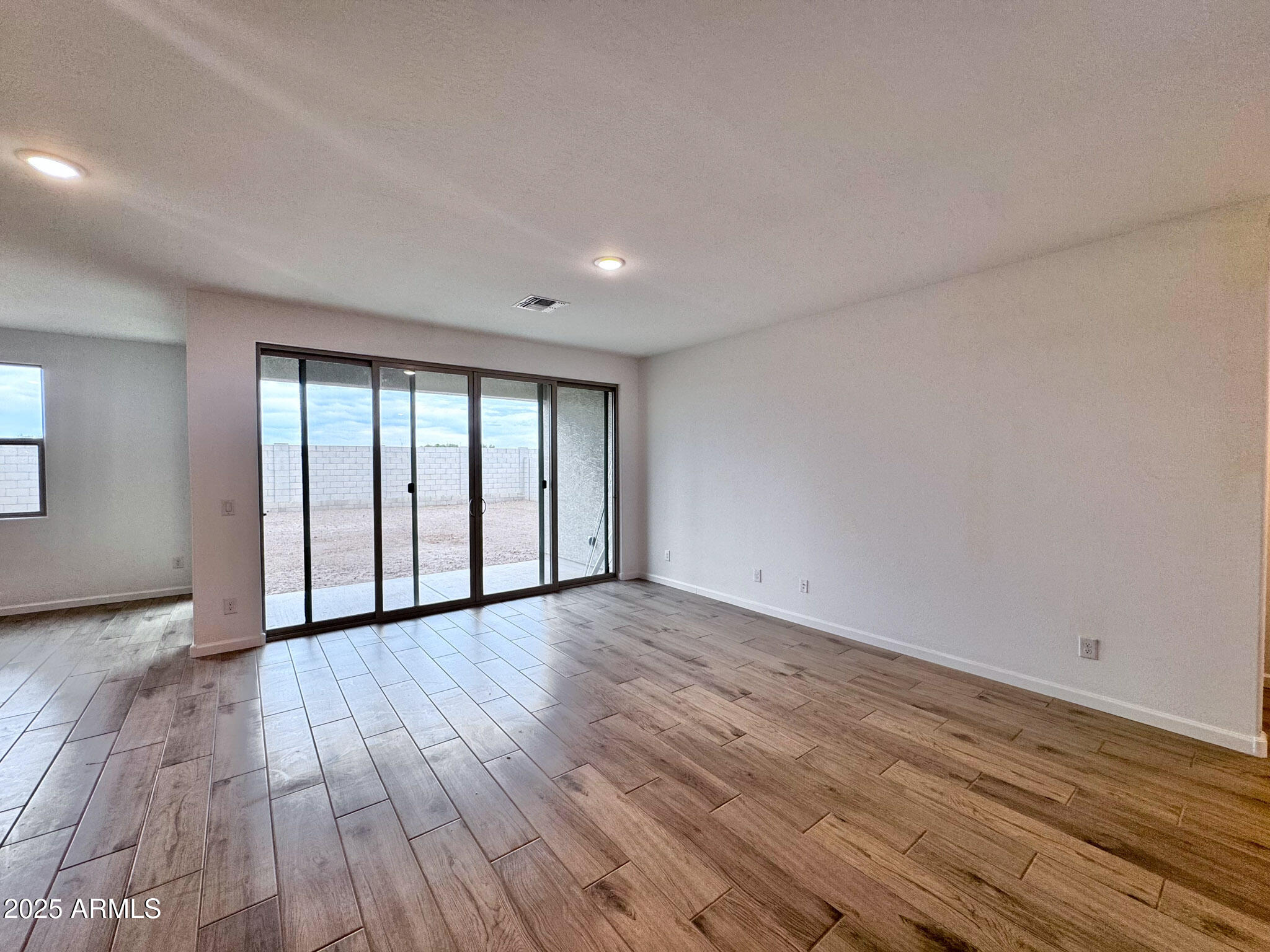 15740 West Camden Avenue Waddell, AZ 85355 - Photo 16 of 38 a view of an empty room with wooden floor and a window