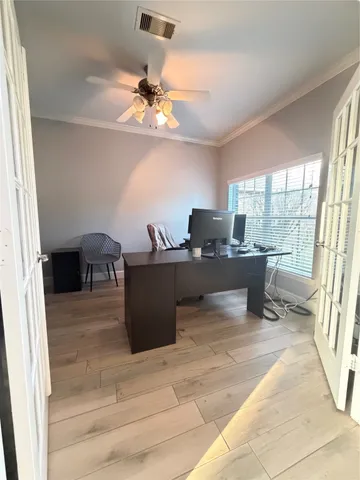 a view of a workspace with furniture and a window