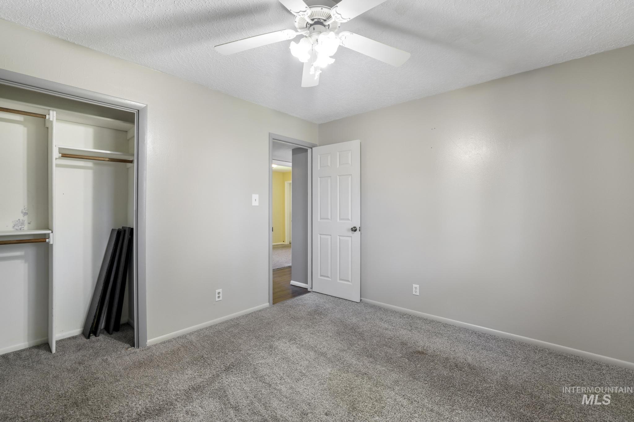 712 Locust Street Kimberly, ID 83341 - Photo 20 of 26 Room featuring a window, textured ceiling, ceiling fan, and carpeted flooring