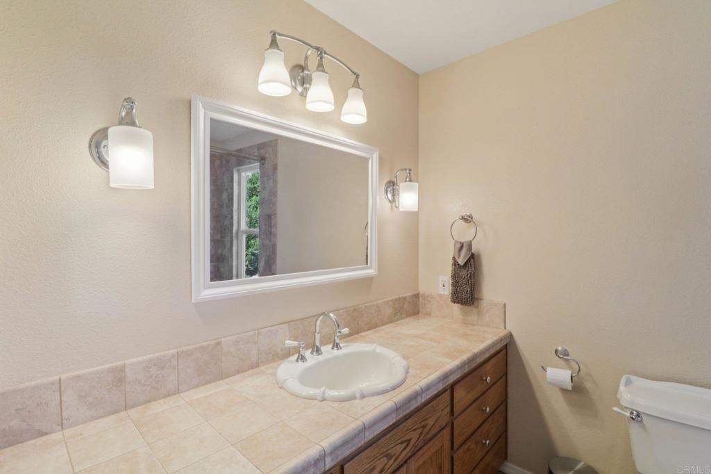1921 Via Corina Alpine, CA 91901 - Photo 37 of 62 a bathroom with a granite countertop sink a toilet and a mirror